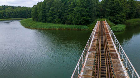 Iron steel frame construction of narrow gauge railway bridge across the river or lake. Bridge with the narrow gauge railway. Aerial view.の写真素材
