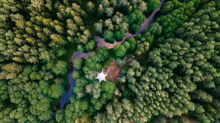 Top view camping in the holidays. Tourist tents in the forest on the river bank. Aerial view.の写真素材