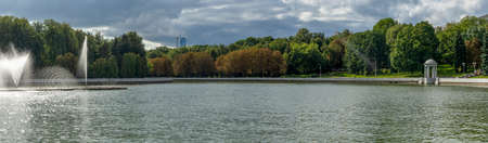 Water from the fountain. Top of high water stream of fountain behind cloudy sky. Fountain in river against dramatic sky.の写真素材