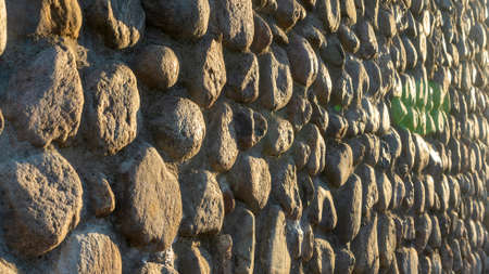 Real backround with gray crushed stones and sunbeam. Old brick wall in a summer day. Abstract...