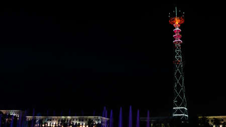 Glowing TV tower at night. Festive illuminated broadcast tower. Space for text.の写真素材