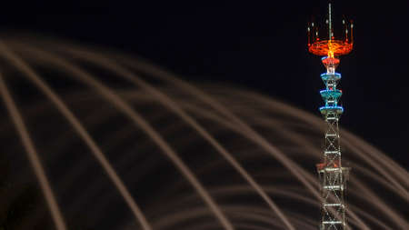 TV Tower in festival illumination. On foreground fountain with long exposure water drop. Minsk Day...