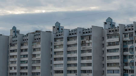 Bottom view of a multi-storey panel residential building on dramatic sky background. Typical post-soviet urban architecture.の写真素材