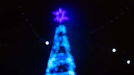 Christmas holiday background. Christmas tree in shining garland in blur. Happy New Year concept.の写真素材
