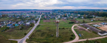 Old water cistern on village and dramatic sky background. Vintage steel watertower in a small town....