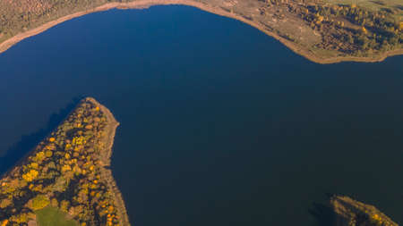 Autumn forest and lake. View from the top. Aerial Photo of an Island in Lake on Sunny Autumn Day. Nature concept.の写真素材