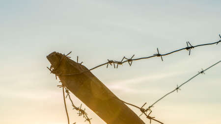 Wooden anti-tank barrier from World War II. Anti Hedgehog Barbed Wire on dramatic sky background. Space for text.の写真素材
