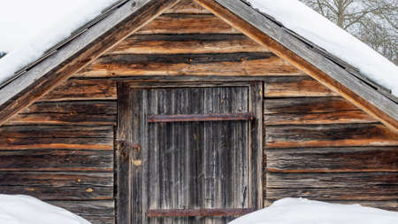 Beautiful winter nature background. Rural landscape with an old barn. Thatched roof barn covered in snow in winter. Nature concept.の写真素材