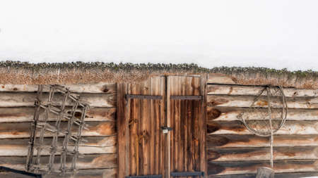 Beautiful winter nature background. Rural landscape with an old barn. Thatched roof barn covered in snow in winter. Nature concept.の写真素材