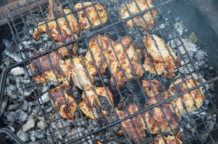 Chicken meat with barbecue sauce cooking on the grill. Fresh chicken breast meat cooked on bbq grid. Cooking concept.の写真素材