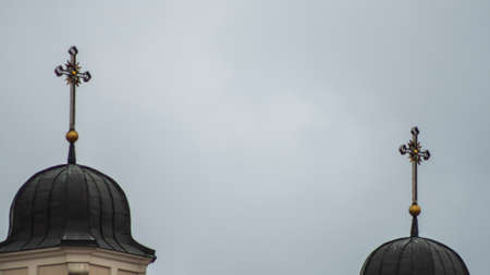 The domes of the Catholic cathedral with crosses on the background of a cloudy sky. Space for text.の写真素材