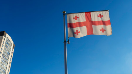 Flag of Georgia against the blue sky with sun rays and lens flare. Diplomacy concept. International relations. Space for text.の写真素材