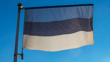 Estonian flag in front of blue sky with lens flare. Diplomacy concept. International relations. Space for text.の写真素材