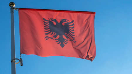 Albania national flag cloth fabric waving on the sky with beautiful sun light. Diplomacy concept. International relations. Space for text.の写真素材