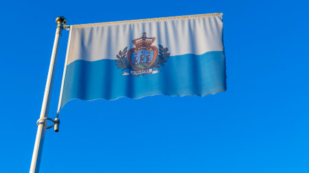 National flag of San Marino on a flagpole in front of blue sky with sun rays and lens flare. Diplomacy concept. International relations. Space for text.の写真素材