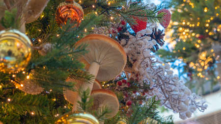 Traditional artificial Christmas tree with Christmas toy, ball and glowing colorful lights in background. Xmas concepts. Close-up of Christmas tree. Defocused background.の写真素材