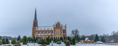 Panoramic view of neo-Gothic cathedral church in the town of Gervyaty in Belarus in the winter on dramatic sky background. Space for text. Religion and historical heritage concepts.の写真素材
