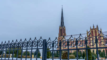 Neo-Gothic cathedral church in the town of Gervyaty in Belarus in the winter on dramatic sky background. Space for text. Religion and historical heritage concepts.の写真素材