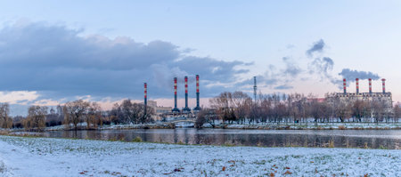 Smoking chimneys of thermal power plants near the waterfront in city. Winter. Industrial and nature background. Ecological concepts.の写真素材