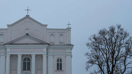The Church of saints Cosmas and Damian in Ostrovets Grodno region with branch of tree on gray sky...