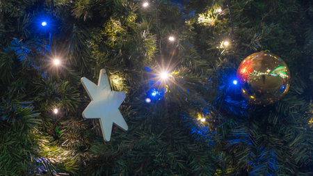 Close-up view of decorated Christmas tree. Beautiful Christmas tree decorated with shiny baubles and...