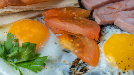 Scrambled eggs with ham, tomato and parsley. Scrambled eggs with ham, tomato and parsley. A rich...