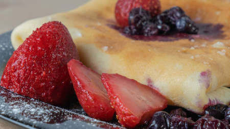 Classic american pancake with berry on black plate background. Top view of crepe with blueberry and...