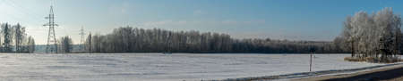 Winter farmland scenery landscape under snow with trees on background. Winter landscape with snow covered countryside. Space for text.の写真素材