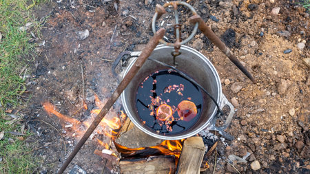 Mulled wine in a tourist pot over hot camp fire. Mulled wine by the fire. Mulled wine cooked on fire...