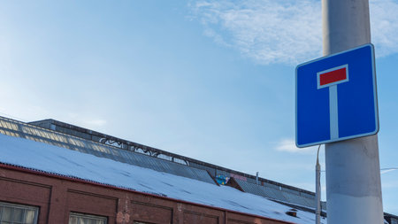 Dead end road sign on blue sky background. A street sign indicates to drivers that the road is a dead end. No exit road sign on sky with clouds background. Space for text.の写真素材