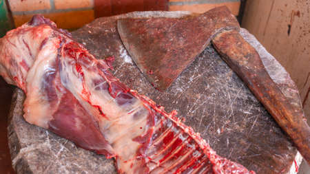 Butchering a beaver hunting trophy on an old wooden deck with a rusty old butchers ax. Butcher shop, butchering game. Hunting trophy concepts.の写真素材