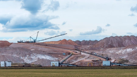 Giant spreader or absetzer machinery. A large dumper on a landfill with potash ore. Extracting and mining potassium salts. Large excavator machine and waste ore in the extraction of potassium.の写真素材
