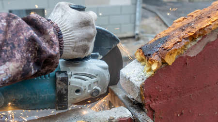 Close-up view of a worker working with angle grinder. Electric wheel grinding on steel structure....