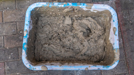 A worker kneads the mixture into plaster buckets. A container with mixed plaster for wall repair. Overhaul and renovation. home improvement.の写真素材