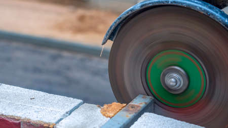 Close-up view of a worker working with angle grinder. Electric wheel grinding on steel structure. Sparks. Angle grinder at work, sparks and dust from the cut-off steel pipe.の写真素材