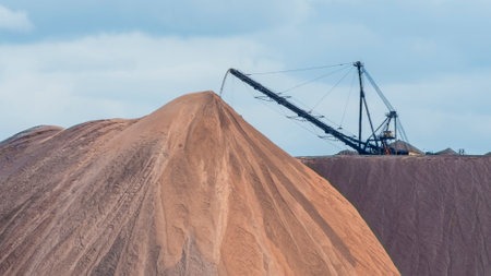 Giant spreader or absetzer machinery. A large dumper on a landfill with potash ore. Extracting and mining potassium salts. Large excavator machine and waste ore in the extraction of potassium.の写真素材