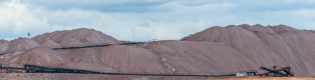 Mountains of empty ore when mining potassium. Transportation of an empty rock to a dump. View of the...