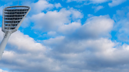High mast on a background of a cloudy sky. Light pole under the blue sky. Space for text. Light pole tower with blue sky.の写真素材