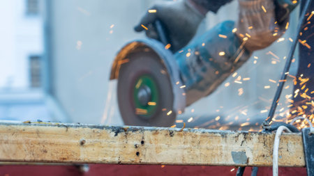 Close-up view of a worker working with angle grinder. Electric wheel grinding on steel structure. Sparks.の写真素材