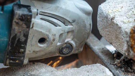 Close-up view of a worker working with angle grinder. Electric wheel grinding on steel structure. Sparks.の写真素材