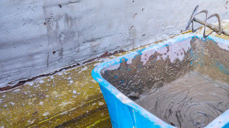 A worker kneads the mixture into plaster buckets. A container with mixed plaster for wall repair....