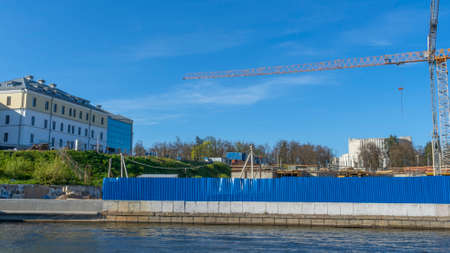 Fences and construction sites with tower crane boom on blue sky background. Space for text....