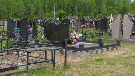 City cemetery with fresh graves, wooden and stone gravestones, metal crosses. city geaveyard. Many...