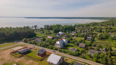 Aerial view of lake and small village. Village near the lake. Aerial view of the village and trees on the shore of lake. nature background.の写真素材