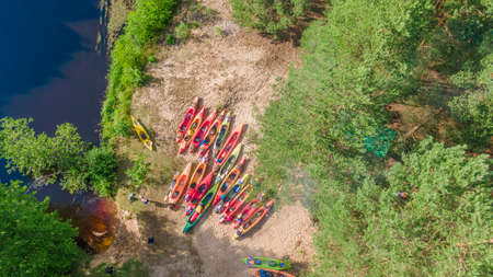 Aerial view of camping with kayaks on the beach of the river on a sunny day. Modern kayaks with paddles on the beach near the river. summer camp activity. travel concepts. nature background.の写真素材