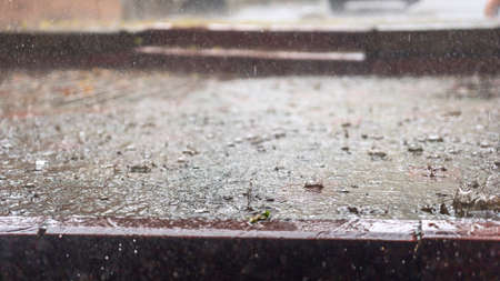 Raindrops in the water. Aqua abstract background. Rain drops on the surface of water in a puddle. Heavy rain drops on asphalt. rain in the city.の写真素材