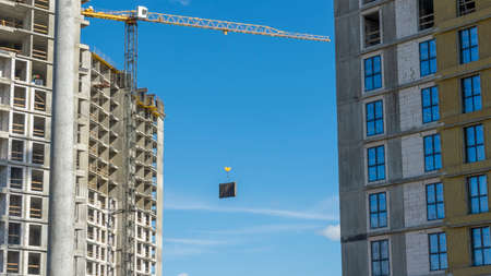 Construction of a multi-story residential buildings. A lot of construction equipment, cranes work. construction site. Big development construction. Sunny summer day.の写真素材