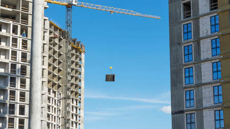 Construction of a multi-story residential buildings. A lot of construction equipment, cranes work. construction site. Big development construction. Sunny summer day.の写真素材