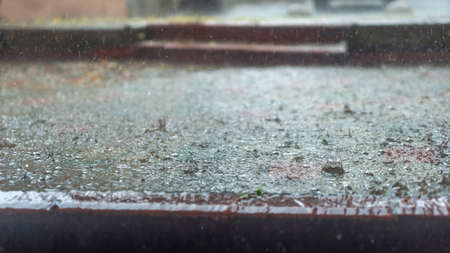 Raindrops in the water. Aqua abstract background. Rain drops on the surface of water in a puddle. Heavy rain drops on asphalt. rain in the city.の写真素材