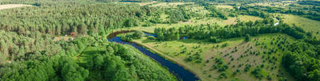 Aerial landscape of winding river in green field and trees. beautiful nature background from drone. Top view of the valley of a meandering river among green fields and forest.の写真素材